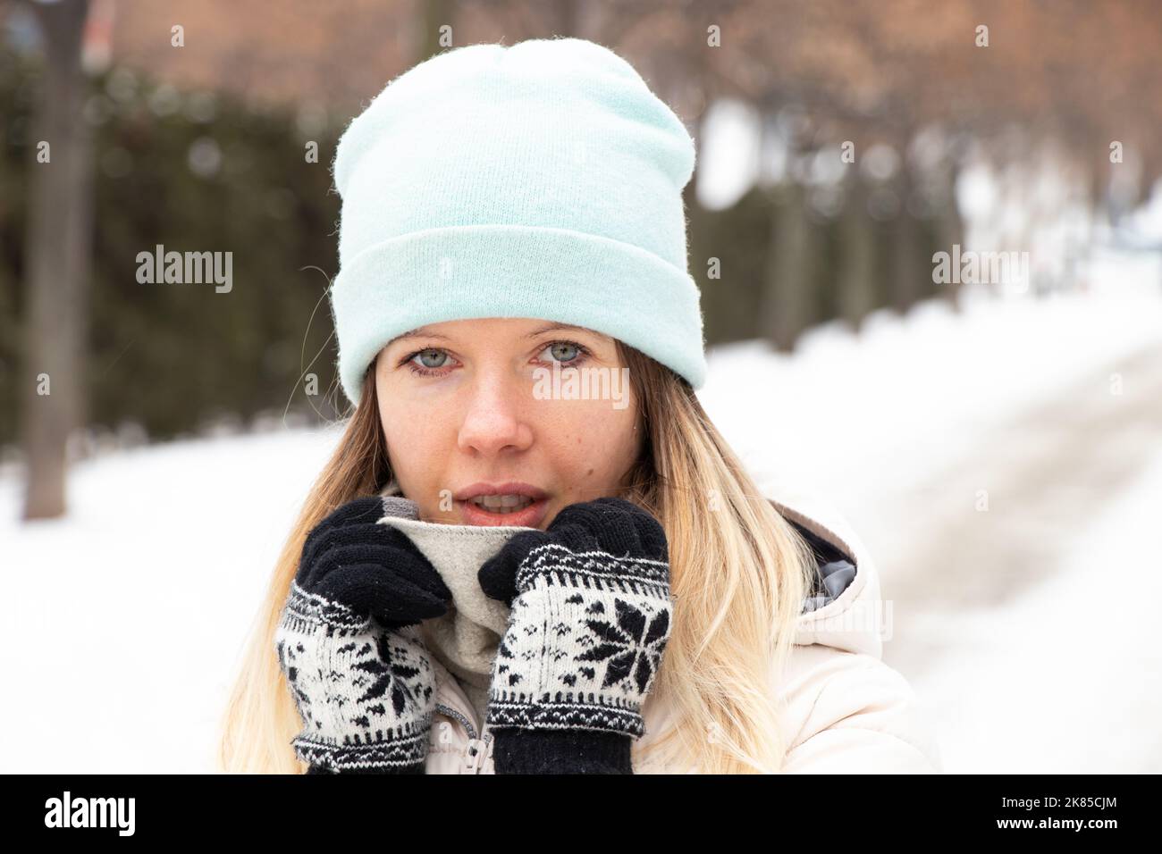 ragazza in inverno in inverno vestiti in città per una passeggiata, ritratto di una ragazza sulla strada in inverno Foto Stock