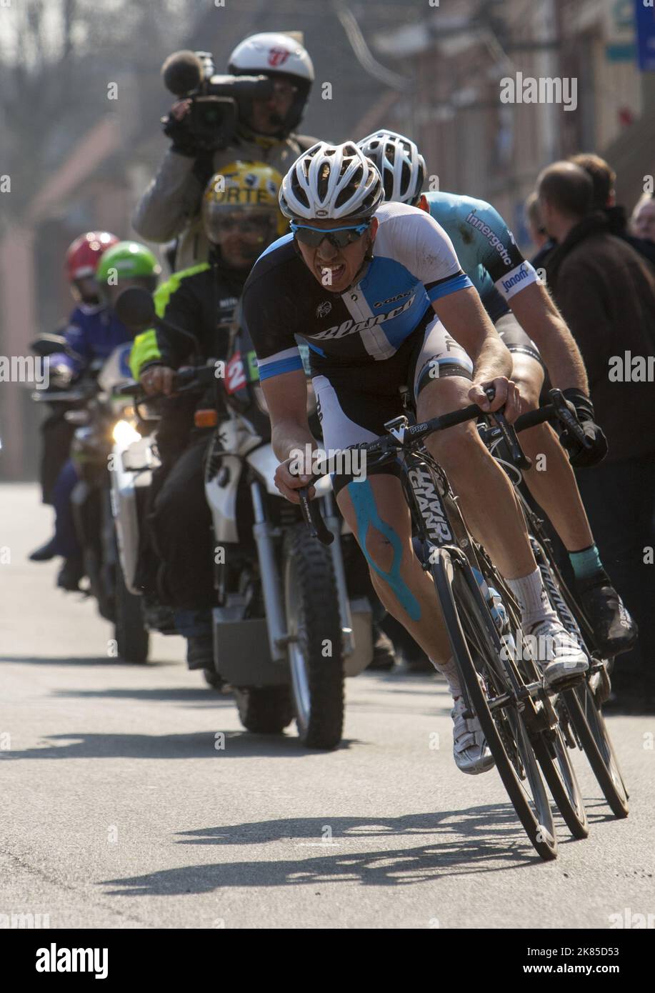 Sep Vanmarcke del Blanco Procicling team leader Stijn Vandenbergh di Omega Pharma Quick Step attraverso il Cysoing prima delle ultime sezioni dure del pavé Foto Stock