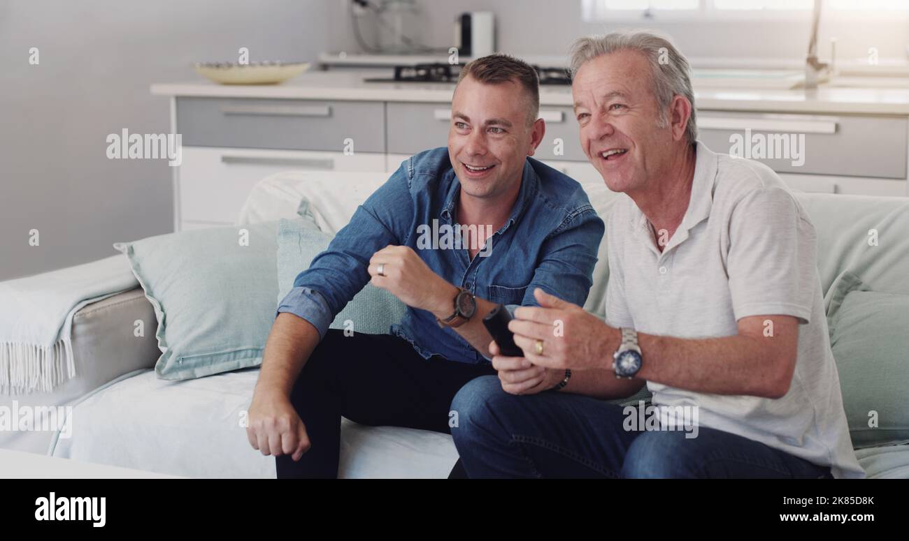 Mi chiedo cosa succederà dopo: Un duo padre-figlio che guarda la tv insieme. Foto Stock