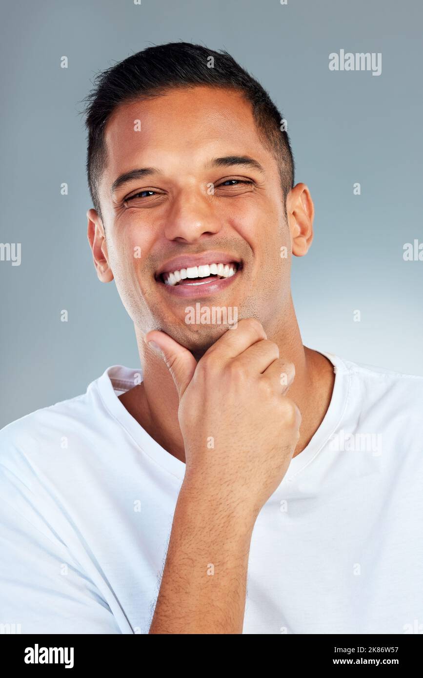 Uomo, ritratto e sorriso con i denti in un'igiene fresca o pulita su uno sfondo grigio studio. Felice maschio sorridente per uno stile di vita sano dentro Foto Stock