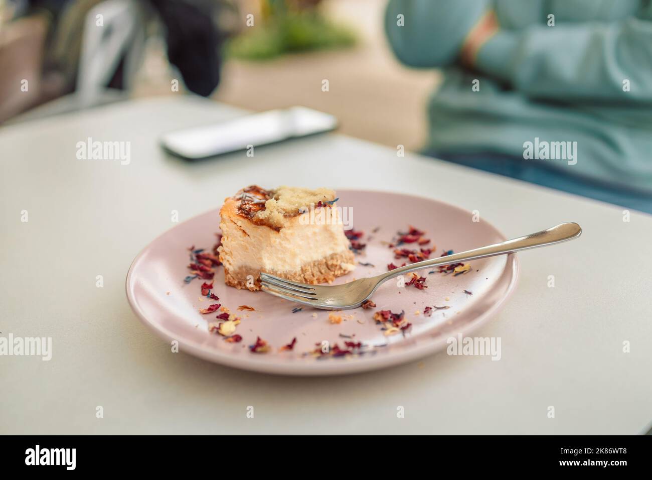 Mangiare cheesecake. Prendere un boccone di cheesecake con forchetta, colazione in luogo pubblico Foto Stock