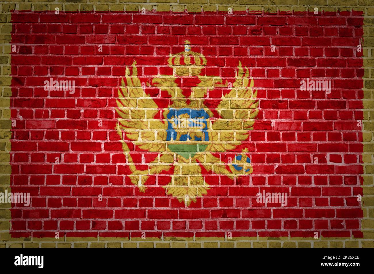 Un'immagine della bandiera del Montenegro dipinta su un muro di mattoni in una collocazione urbana Foto Stock