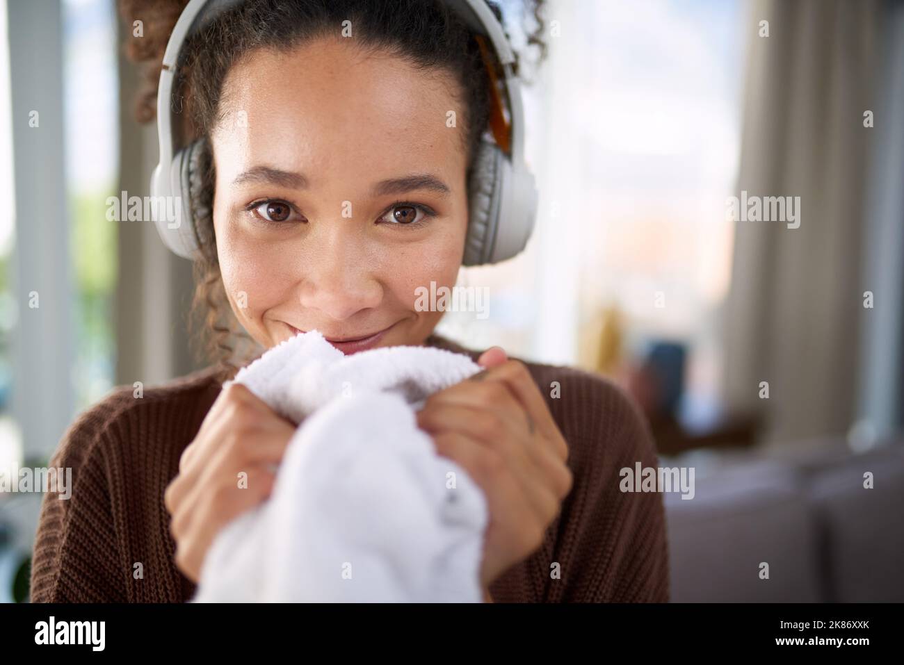Che cosa mi rende felice l'odore del mio ammorbidente del tessuto. Una donna che odora il bucato appena lavato mentre si siede a casa. Foto Stock