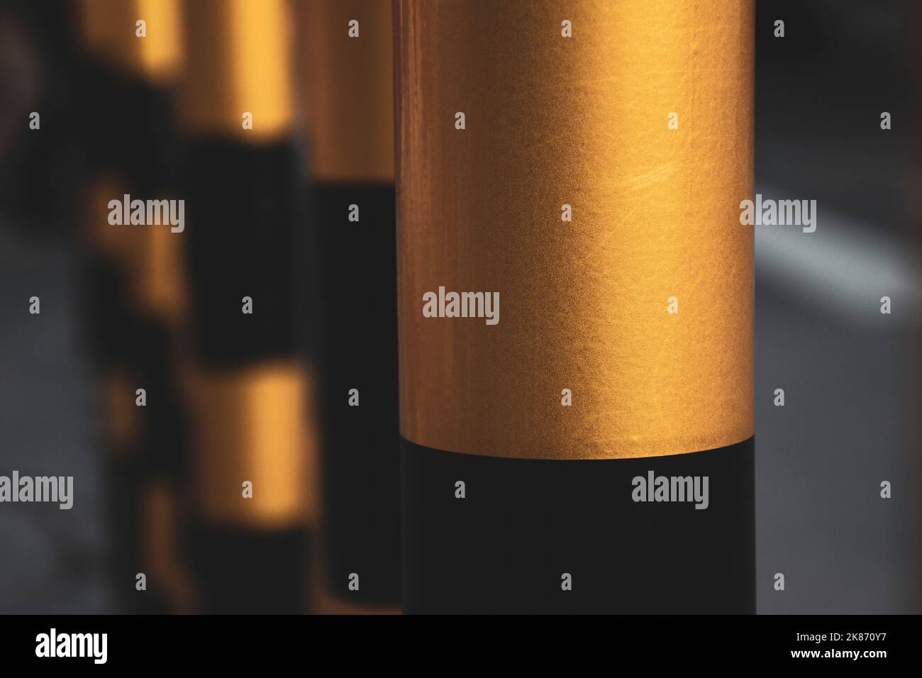 Un primo piano di tubi metallici dipinti in nero e oro Foto Stock