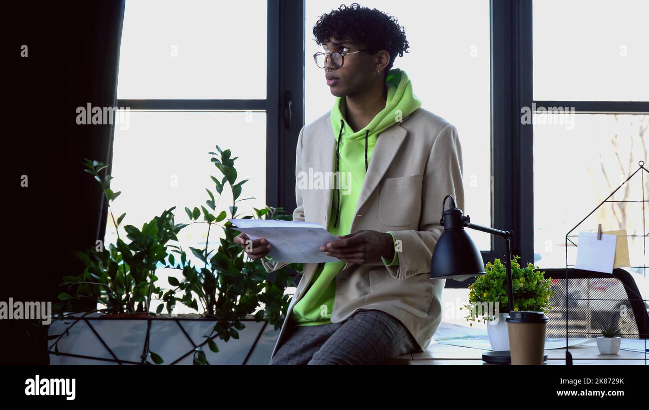 Giovane designer afro-americano in occhiali con disegni in studio Foto Stock