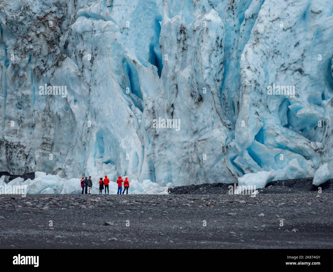 Turisti che si trovano di fronte al ghiacciaio Aialik, uscendo dal campo di ghiaccio Harding, dal Kenai Fjords National Park, Alaska, Stati Uniti d'America Foto Stock
