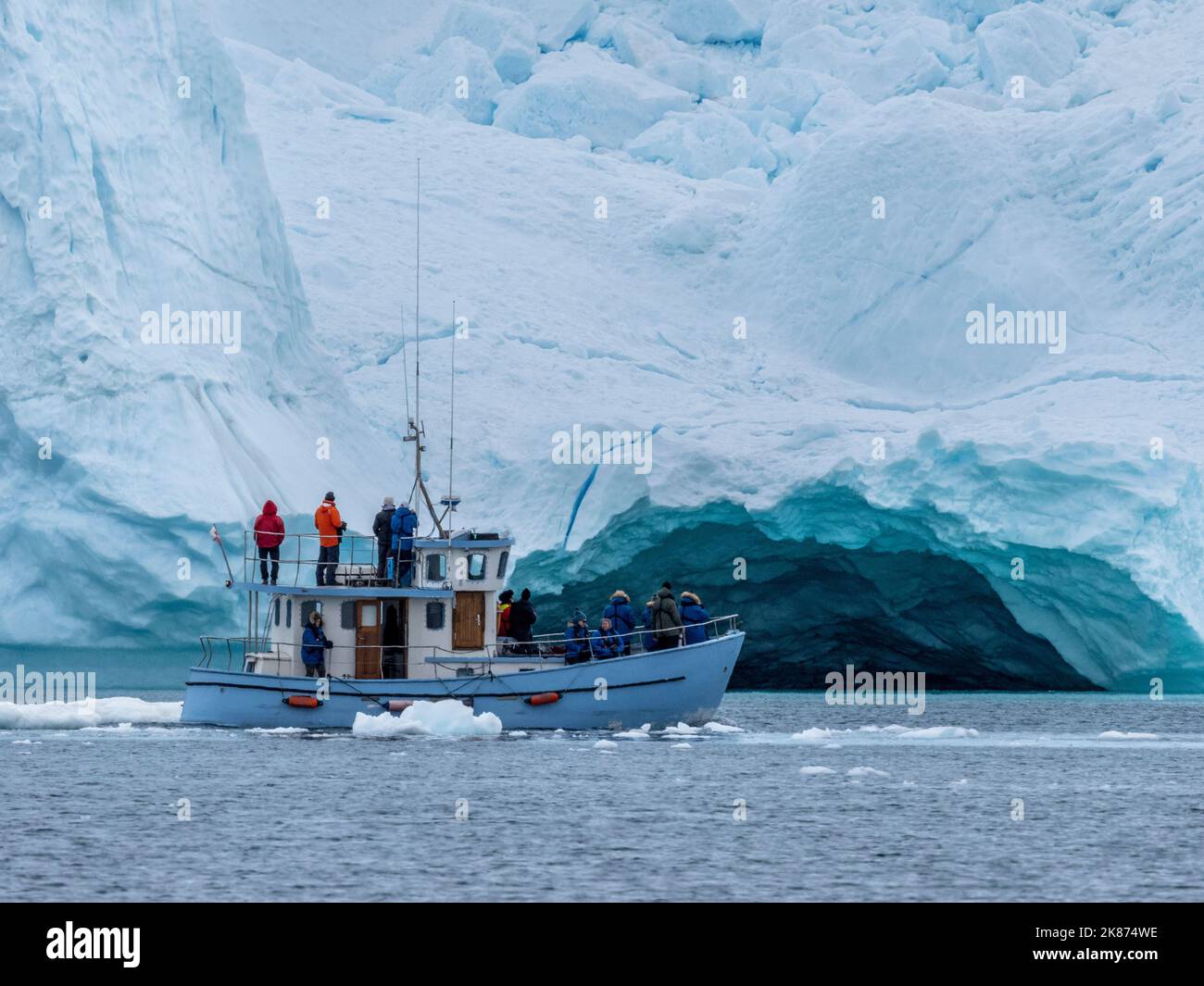 I turisti che partecipano a un tour sul ghiaccio in una piccola barca che guarda gli iceberg dall'Icefjord di Ilulissat, appena fuori Ilulissat, Groenlandia, Danimarca, regioni polari Foto Stock
