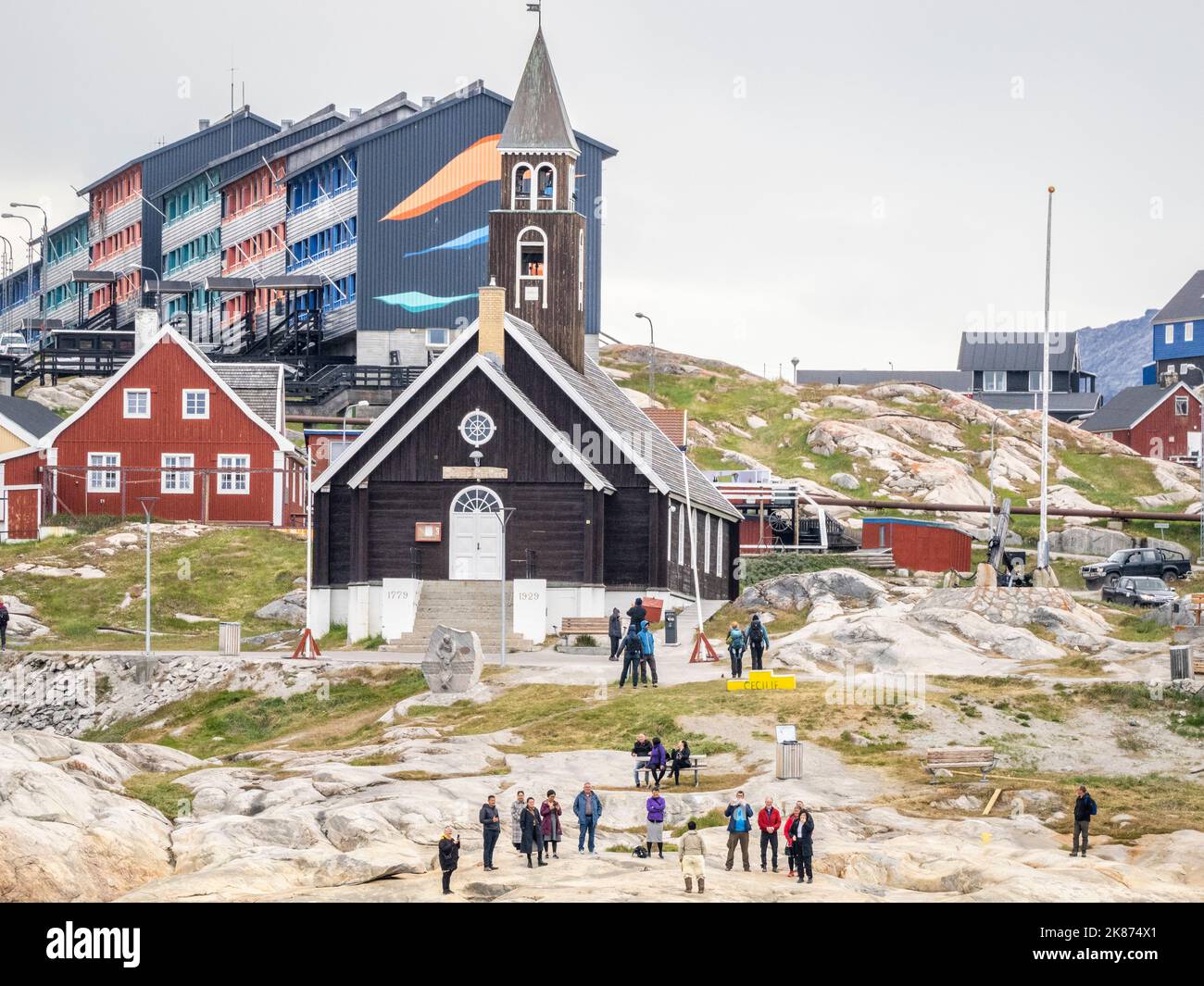 Una vista della Chiesa di Sion circondata da case dipinte di colori nella città di Ilulissat, Groenlandia, Danimarca, regioni polari Foto Stock