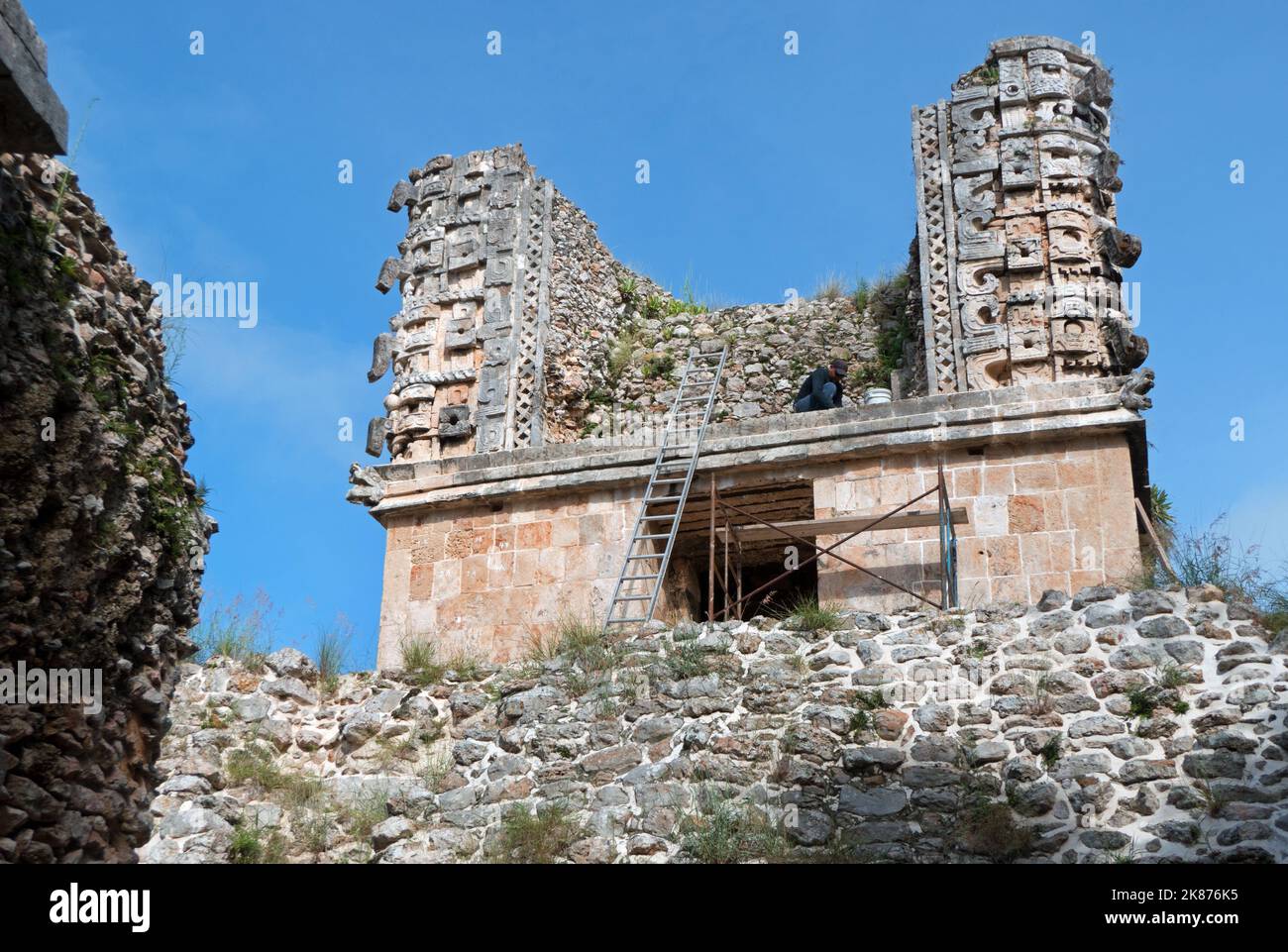 Uomo che lavora nel sito archeologico Maya di Uxmal a Yucatan, Messico. Rovine Maya con il Quadrangle Nunnery come vecchio edificio in manutenzione e. Foto Stock