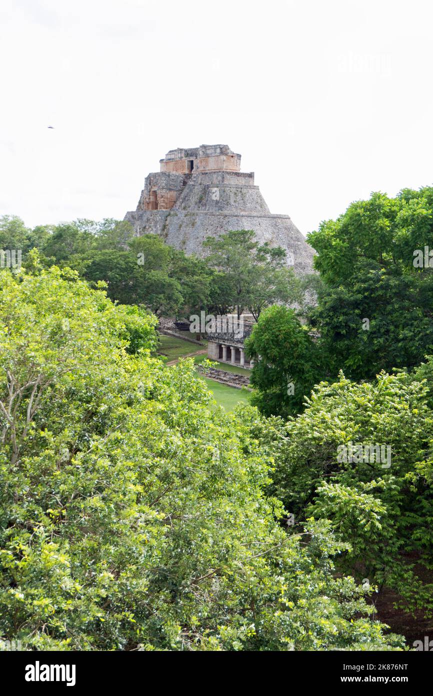 Vista del sito archeologico Maya di Uxmal a Yucatan, Messico. Rovine Maya con piramide del mago e antichi edifici per i turisti e trave Foto Stock