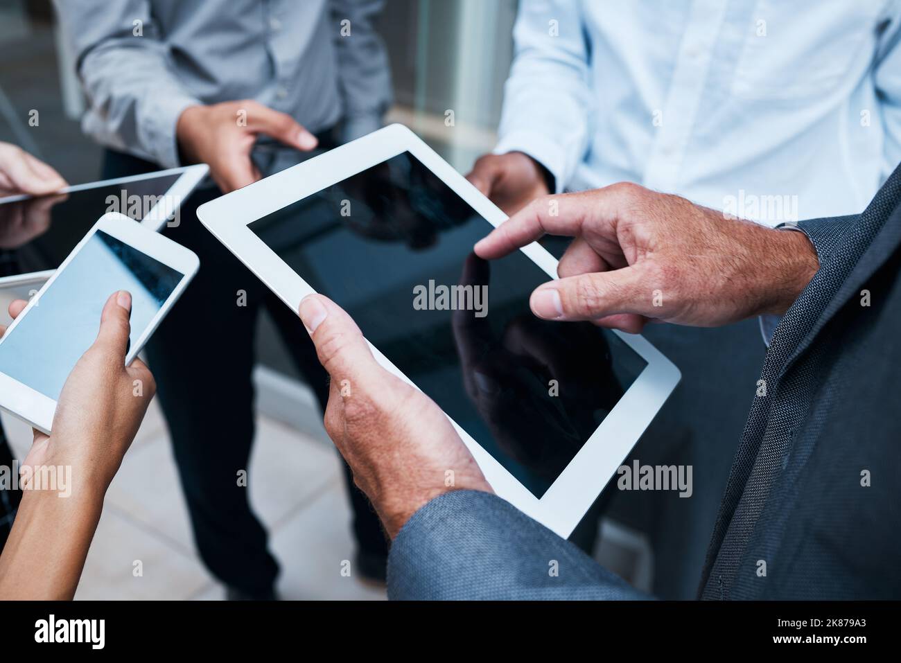 La potenza della tecnologia vi stupirà. Le mani degli uomini d'affari che utilizzano vari dispositivi. Foto Stock