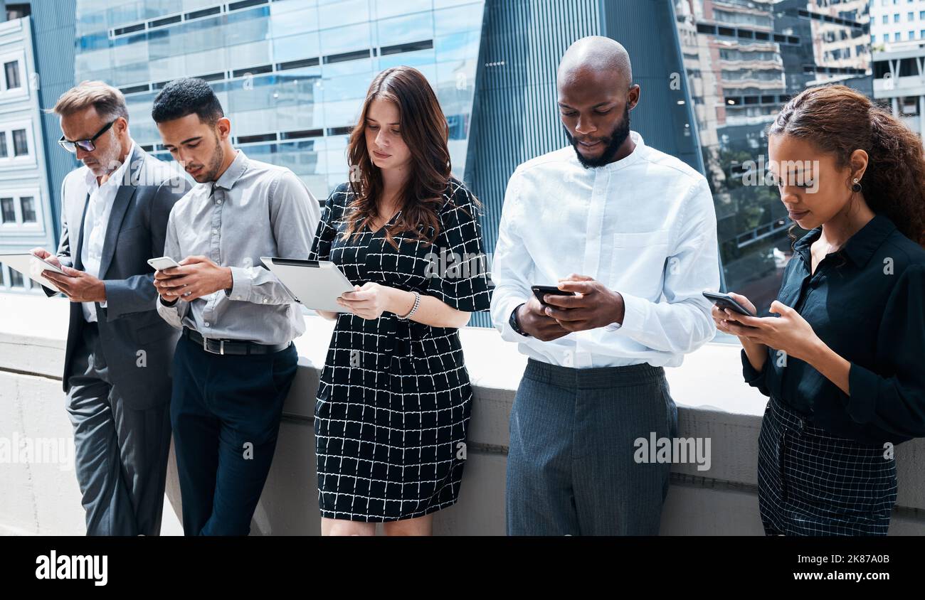 Erano tutti sulla stessa riunione accanto a un altro. Businessspeople usando i vari dispositivi contro un background urbano. Foto Stock