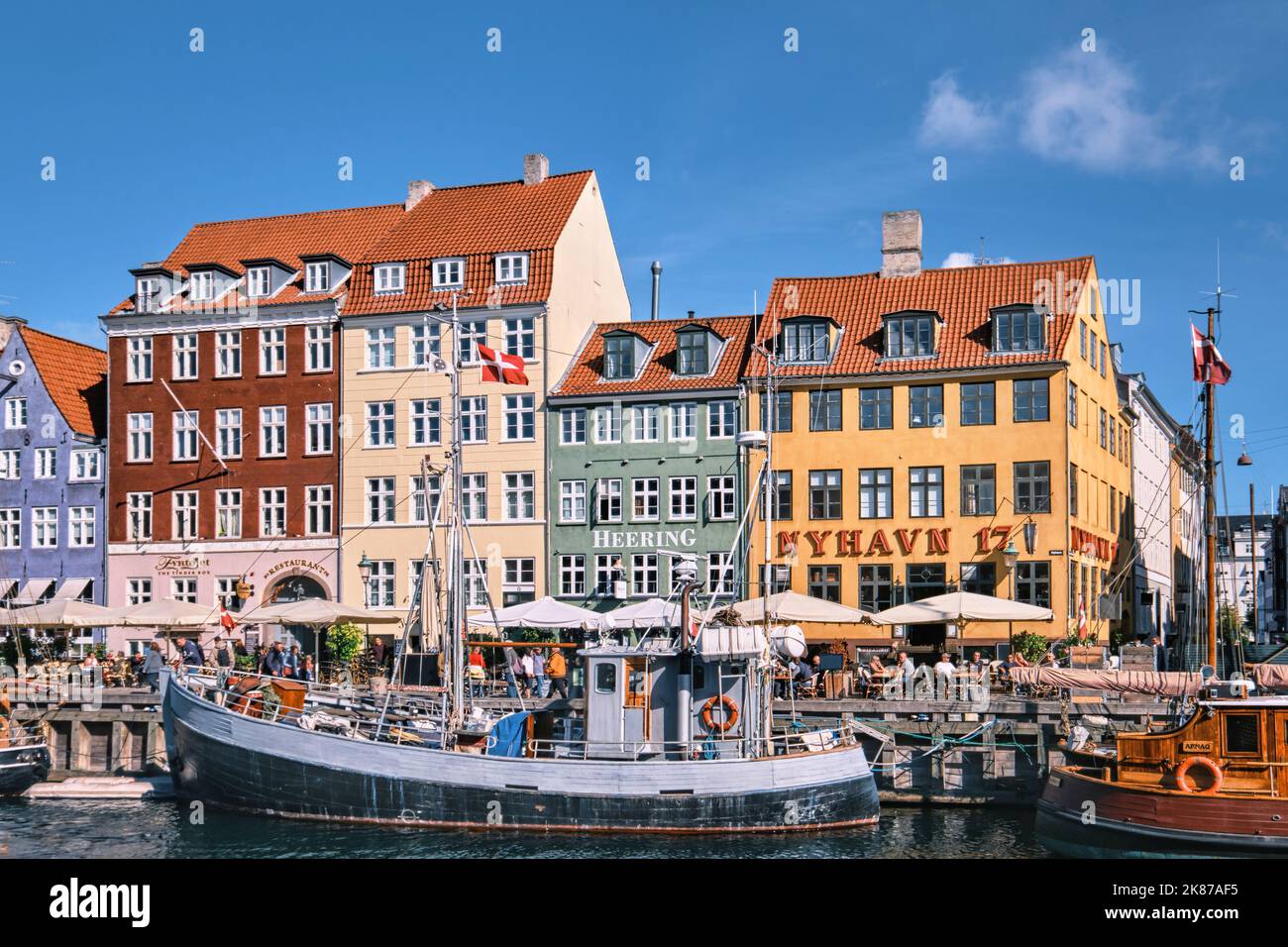 Copenaghen, Danimarca - Settembre 2022: Colorata architettura tradizionale casa e barche sul terrapieno del canale nel porto di Nyhavn Foto Stock
