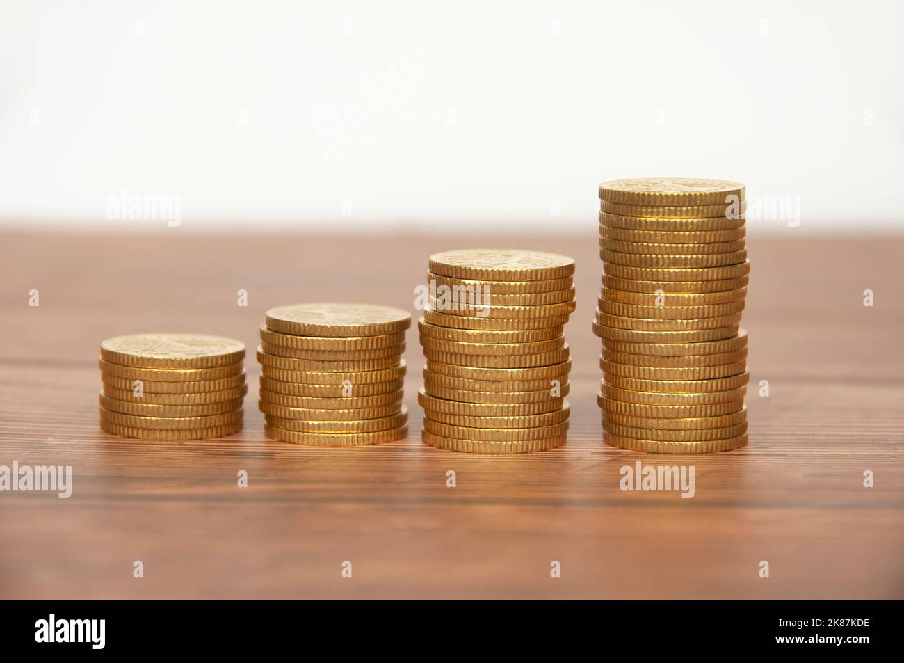 Monete d'oro su tavolo di legno. Concetto di crescita della ricchezza e del business. Foto Stock