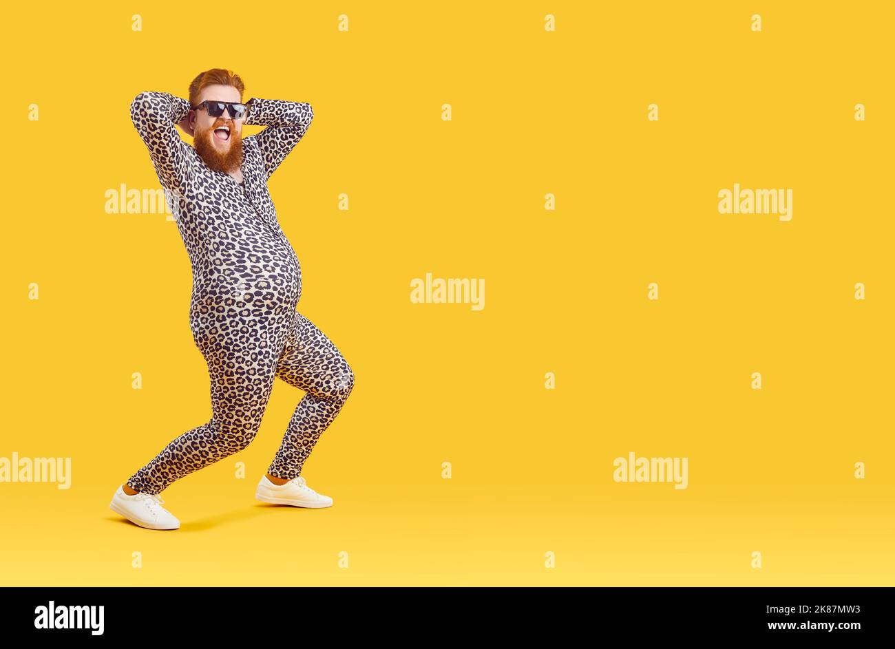 Pazzo divertente grasso uomo con grande pancia in pajama vestito con stampa leopardo è ballare e folgorare intorno. Foto Stock