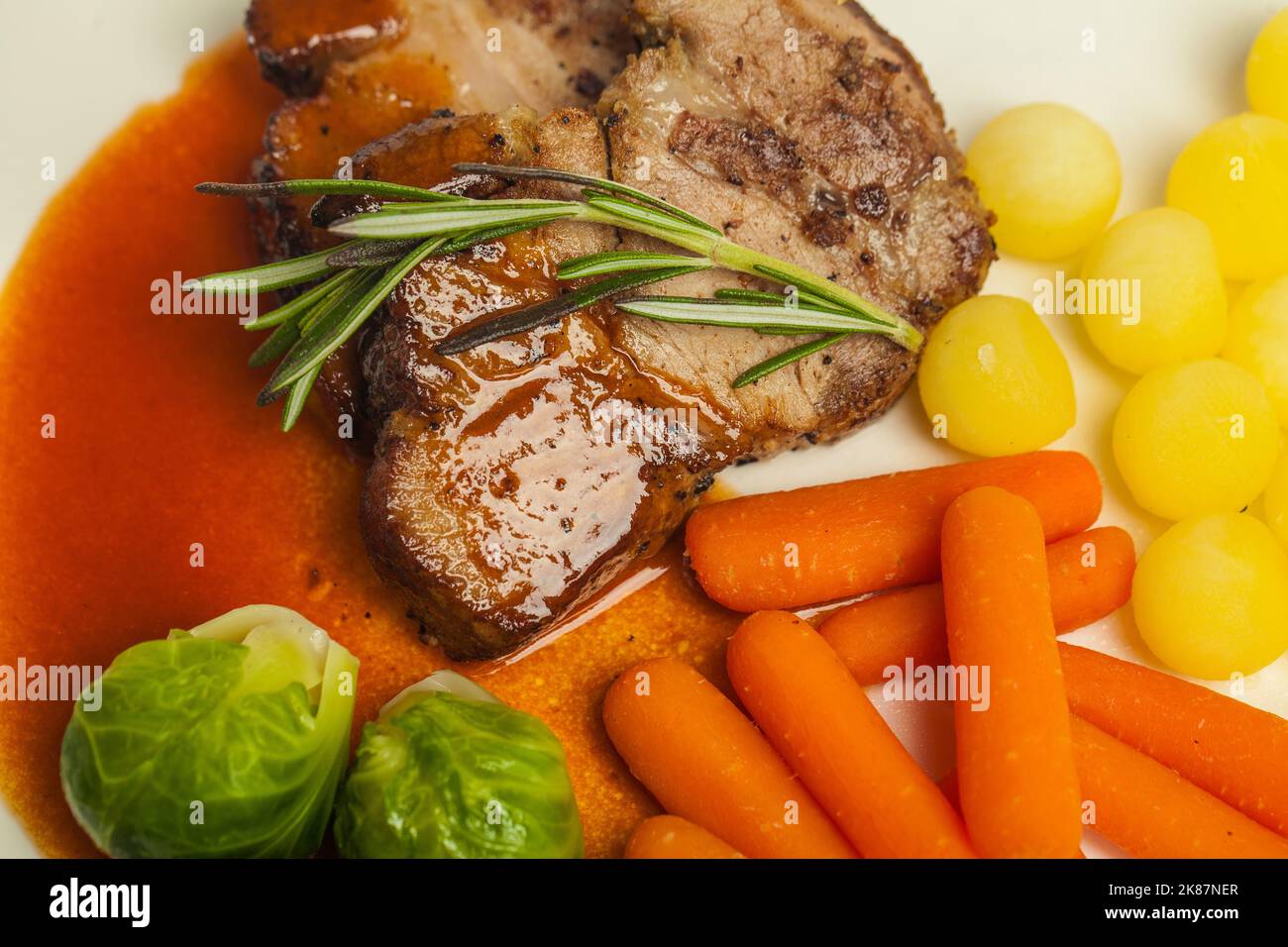 Bistecca alla griglia con verdure, carote, patate e germogli di bruxelles Foto Stock