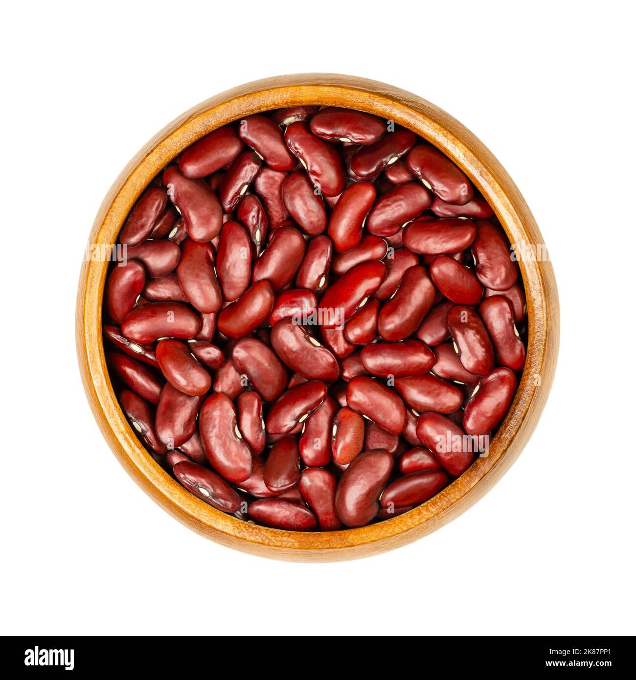 Fagioli rossi di rene, in una ciotola di legno. Fagioli comuni secchi, una varietà del fagiolo comune, Phaseolus vulgaris. Cibo vegetariano di base. Foto Stock