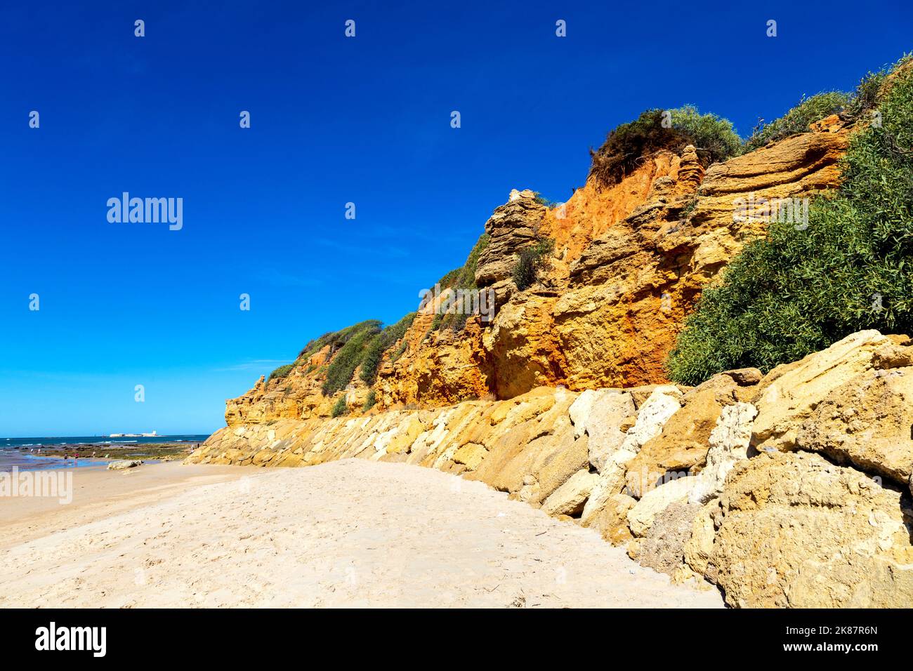 Rocce arancioni lungo Playa Sancti Petri, Costa de la Luz, Cadice, Spagna Foto Stock