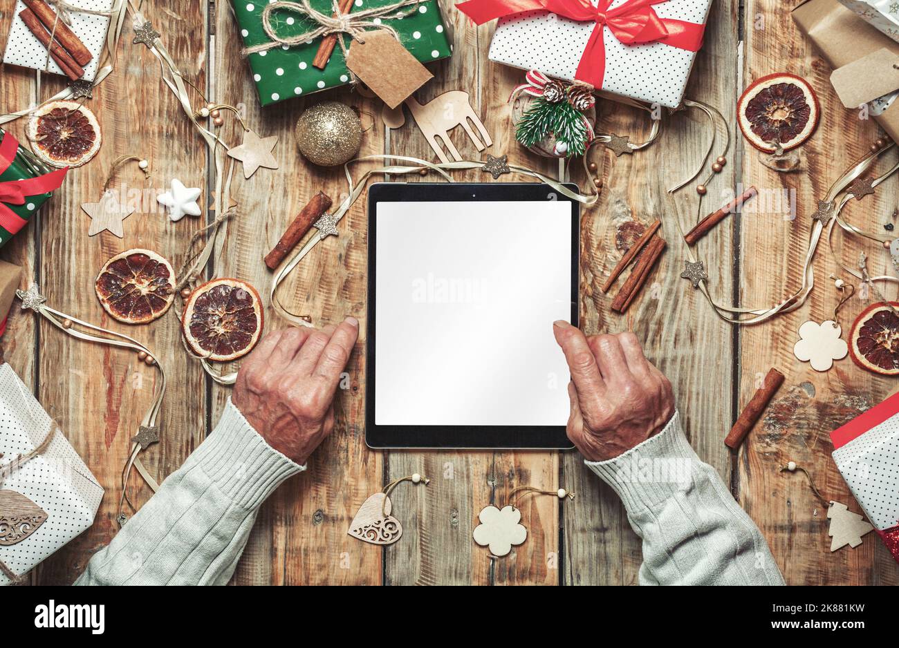 Mani di anziani con tablet, shopping online sul tavolo wi Foto Stock