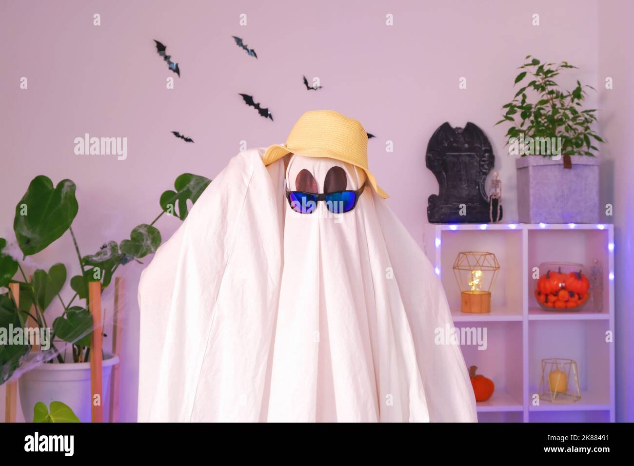 Il fantasma si sta preparando per la vacanza. Il fantasma va su un viaggio, viaggio, viaggio. Concetto di Halloween. Luce al neon. Foto Stock