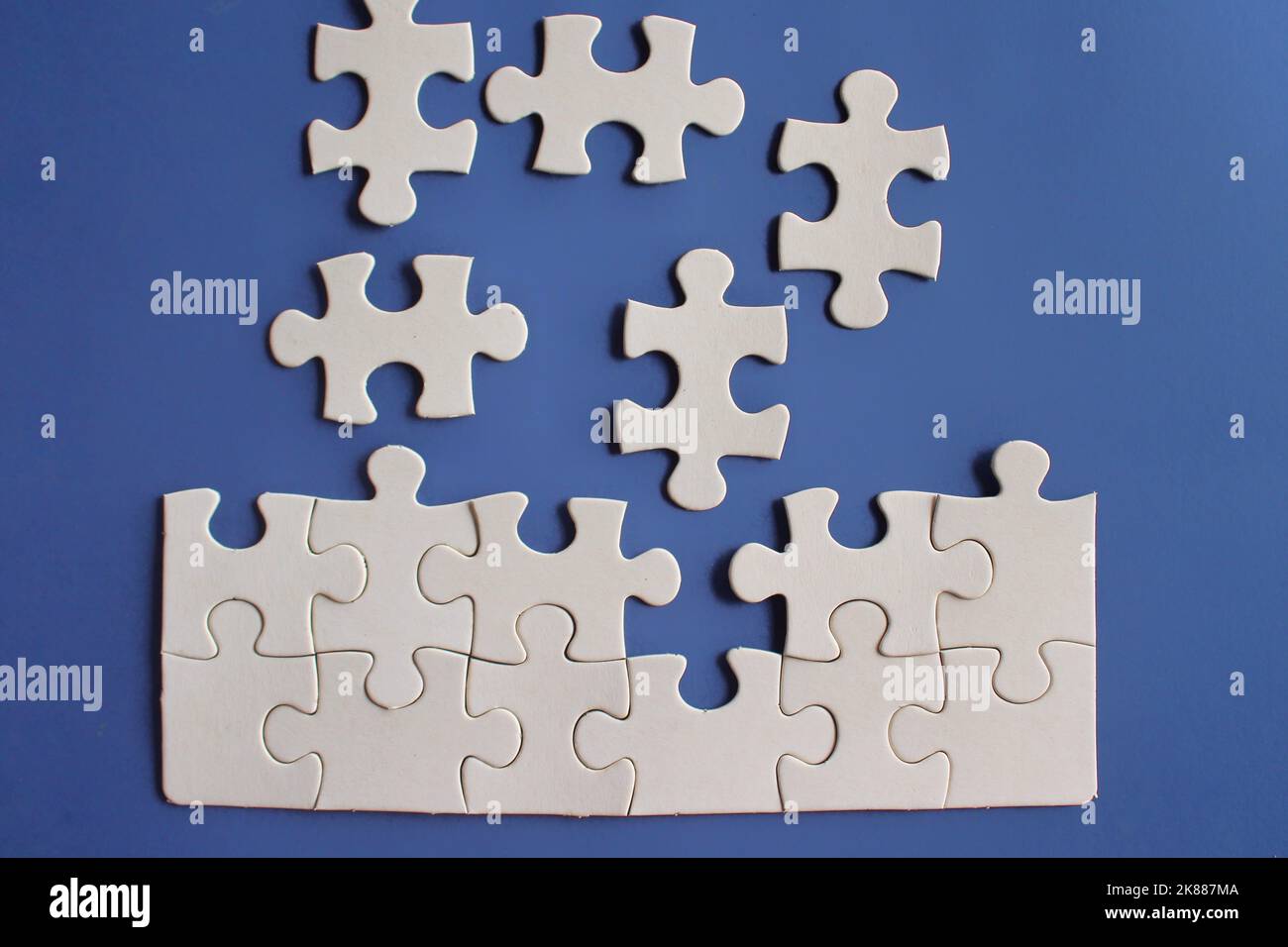 Vista dall'alto immagine di puzzle incompleto su sfondo blu. Foto Stock