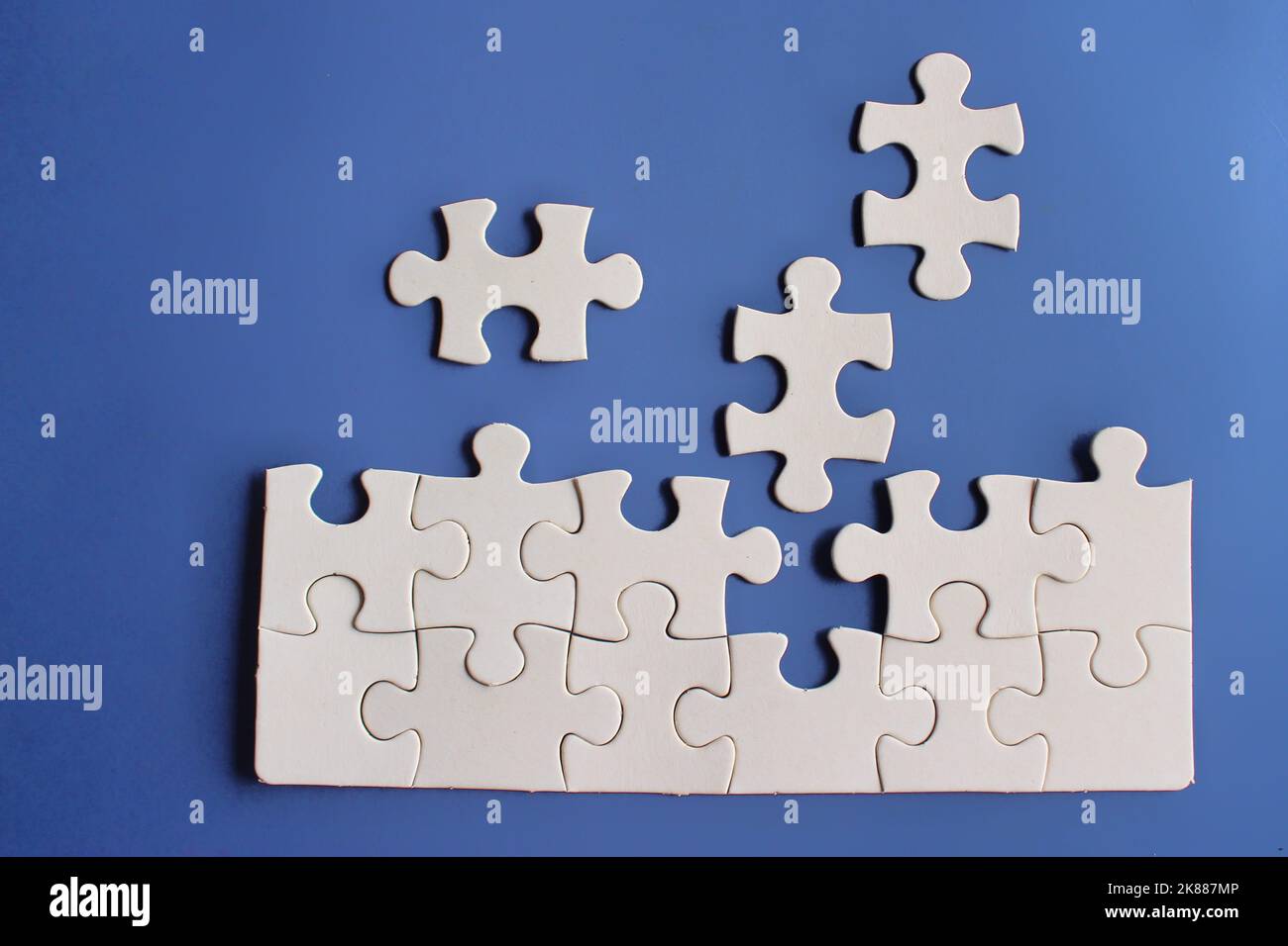 Vista dall'alto immagine di puzzle incompleto su sfondo blu. Foto Stock