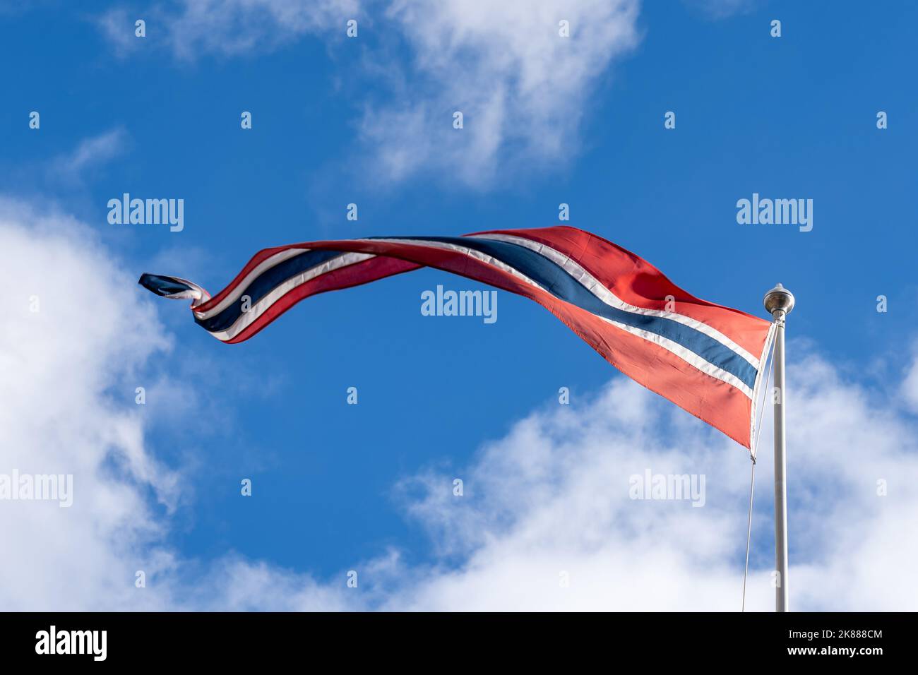 Un Pennant norvegese ondeggiante con il cielo blu sullo sfondo. Foto Stock