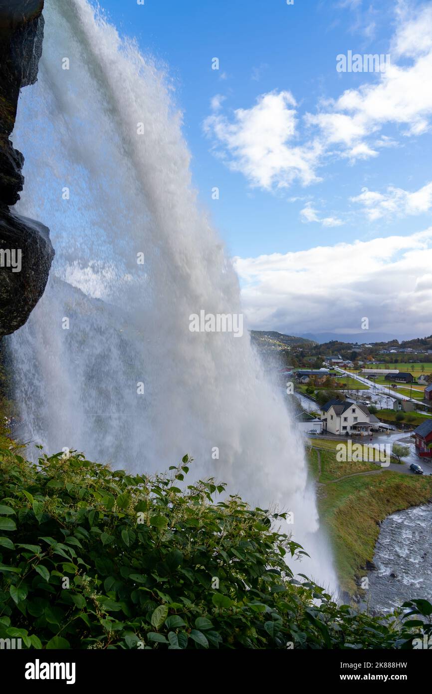 Steinsdalsfossen con il villaggio sullo sfondo, Vestland, Norvegia. Foto Stock