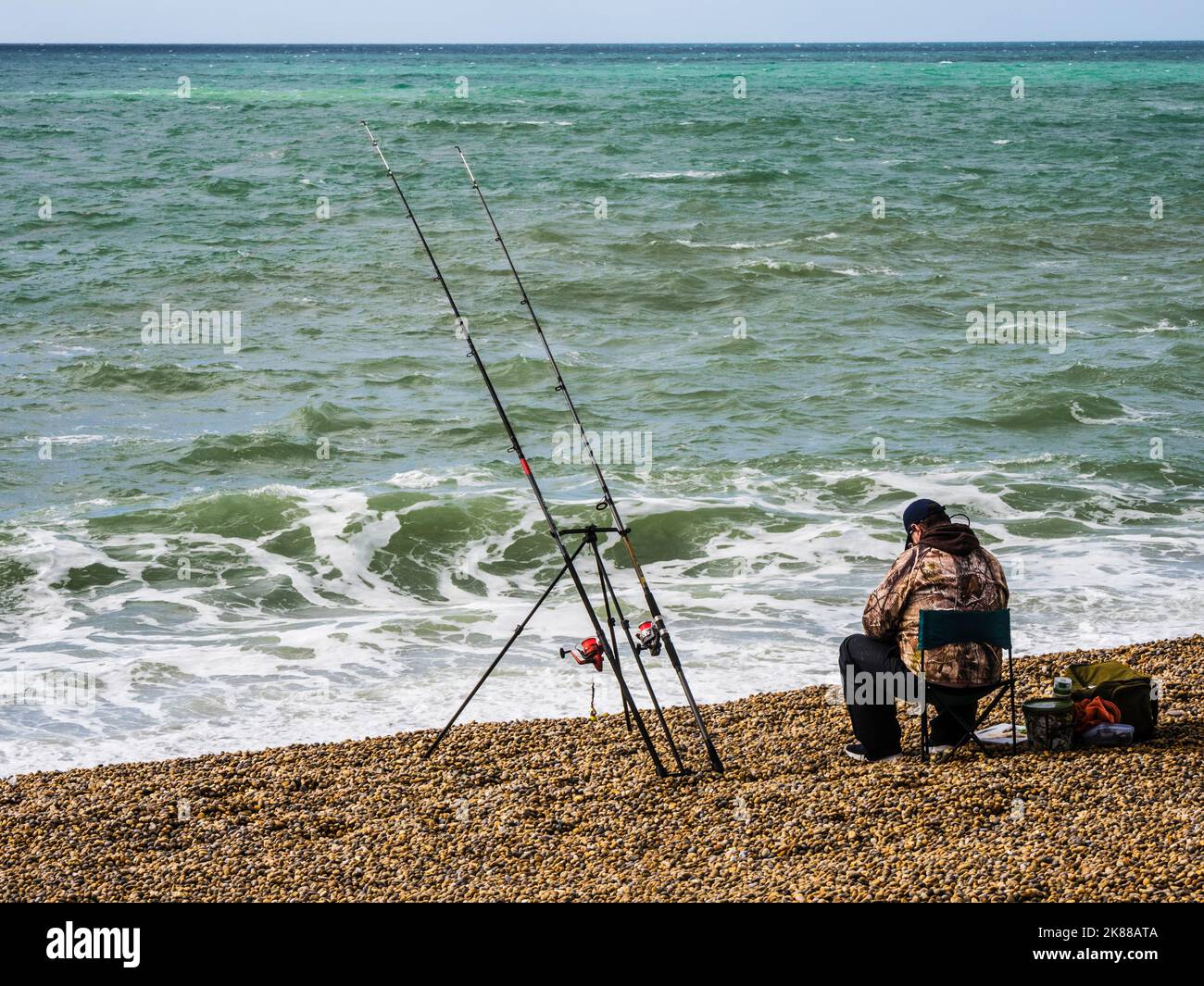 Un pescatore solista sulla spiaggia di Chesil in Dorset. Foto Stock