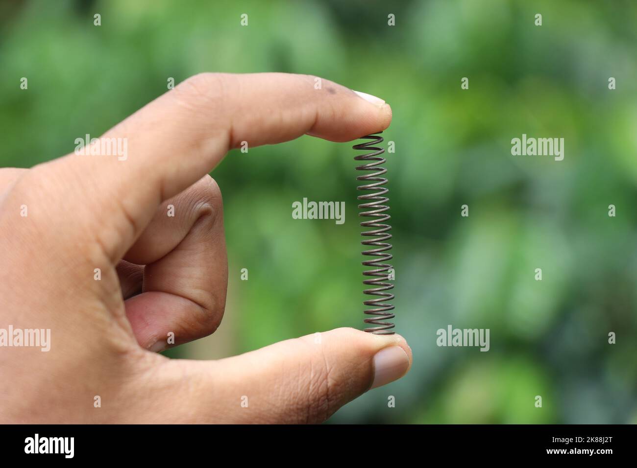 Molle di compressione in metallo utilizzate per assorbire gli urti su varie parti meccaniche in movimento tenute in mano Foto Stock
