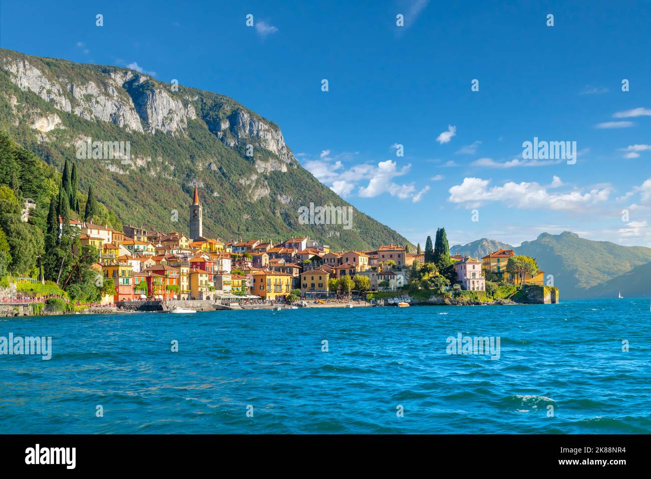 Il colorato villaggio turistico sul lago di Varenna, con case medievali dipinte con colori vivaci e negozi lungo la costa del Lago di Como nel Nord Italia. Foto Stock