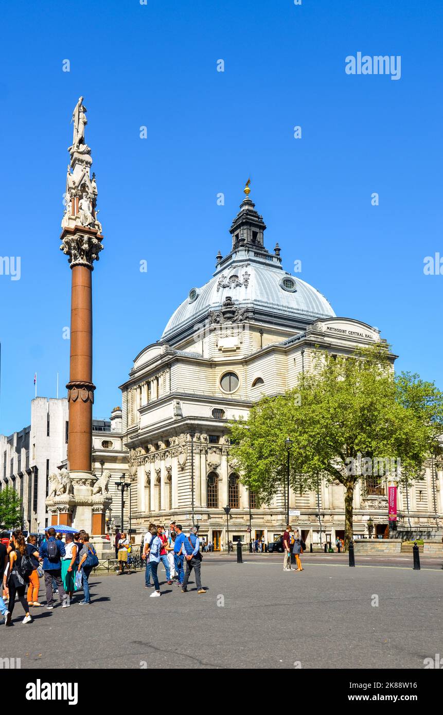 Un'immagine verticale di Central Hall Westminster a Londra, Inghilterra, con persone sul marciapiede, un albero e un cielo blu sullo sfondo. Foto Stock
