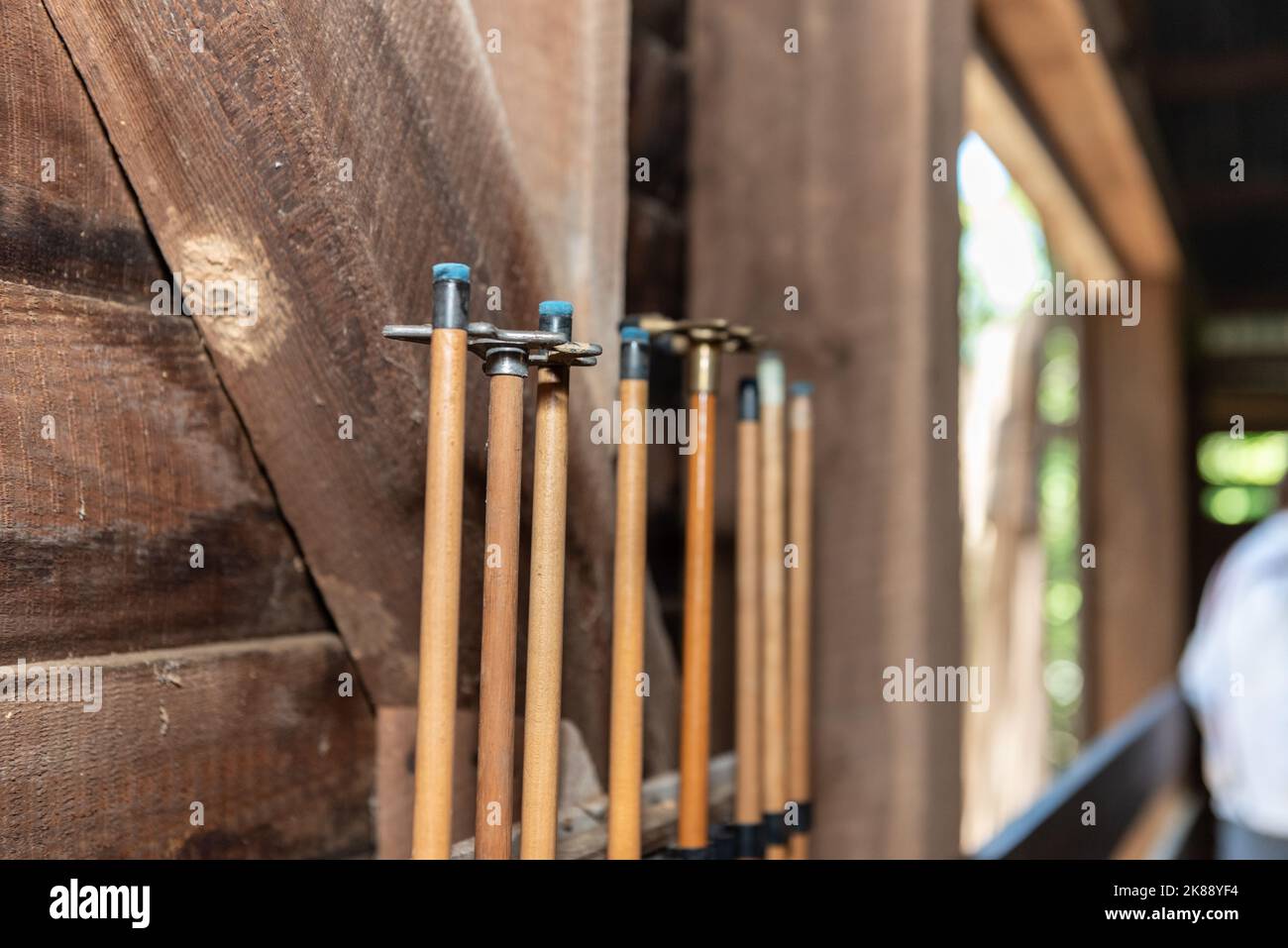 Le punte blu degli spunti della piscina sono immagazzinate in posizione verticale contro la parete del fienile di legno. Foto Stock