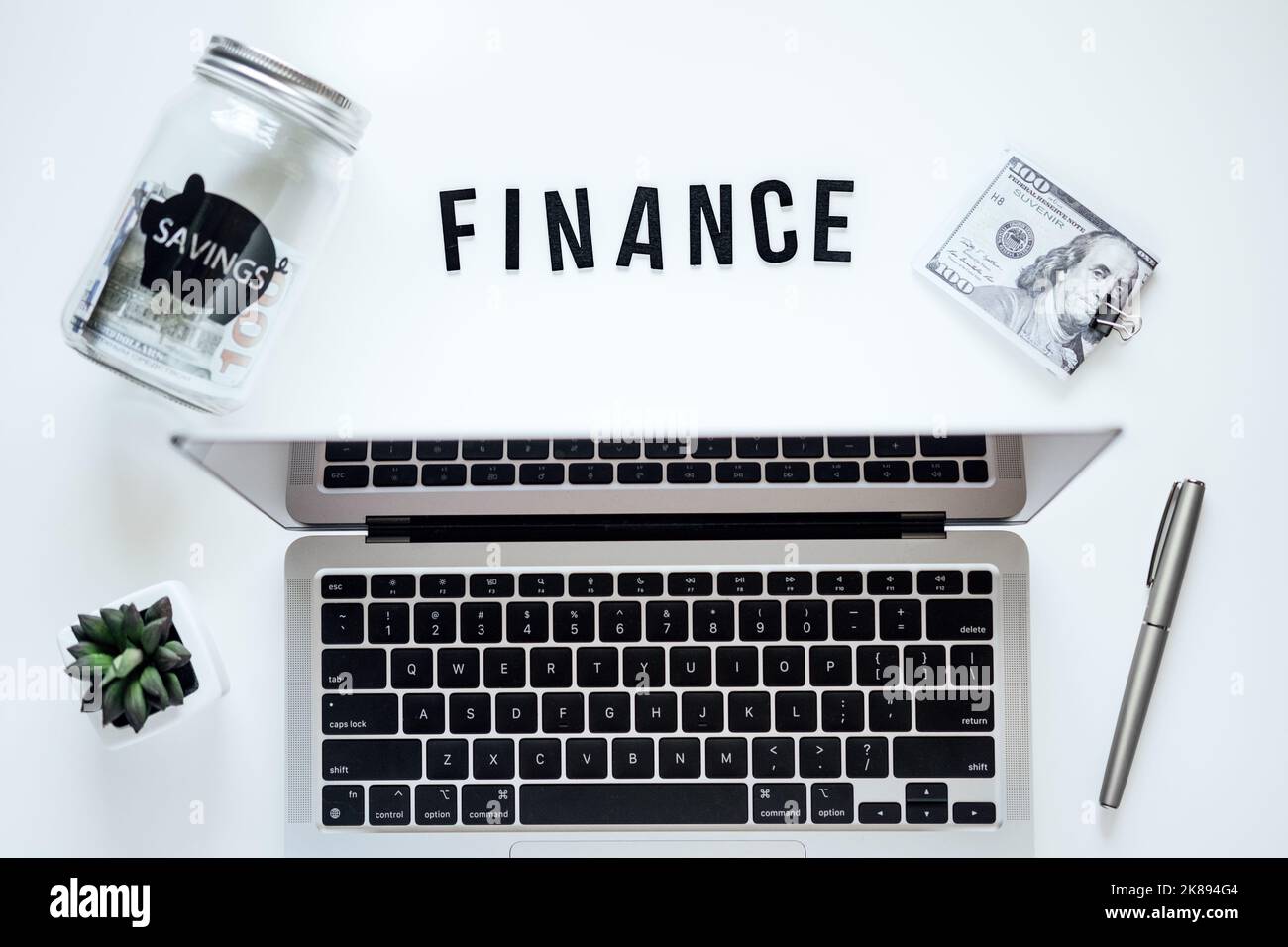 Corsi di finanza Online. Pianificazione del budget. Word Finanza, computer portatile, barattolo mason risparmio banca, cancelleria e occhiali sul tavolo Foto Stock