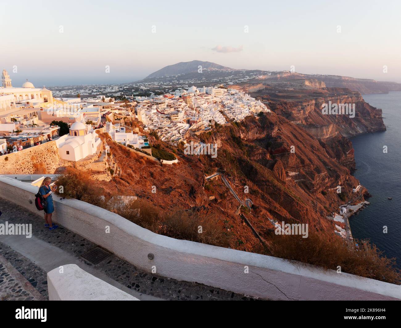 Città di Fira al tramonto da un sentiero costiero con la costa della Caldera. Isole Cicladi greche di Santorini nel Mar Egeo Foto Stock