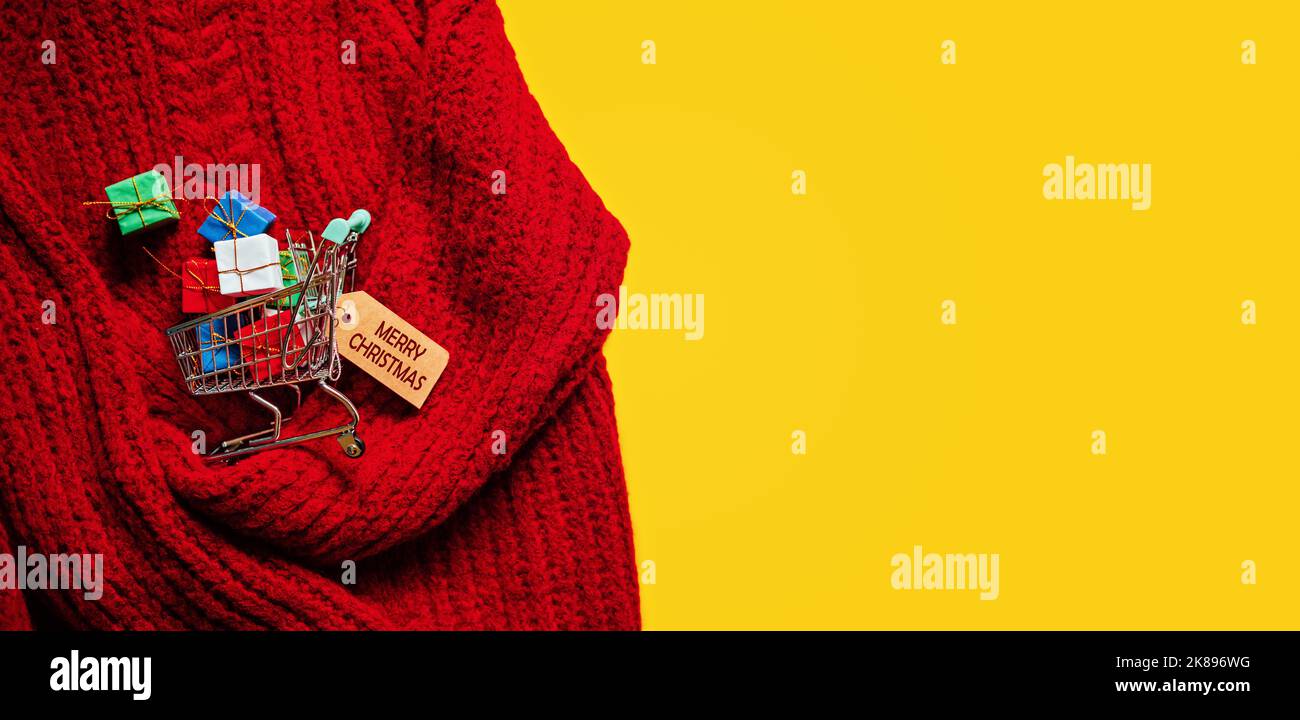 Natale Natale shopping banner. Carrello con molte scatole regalo su maglia rossa e sfondo giallo Foto Stock