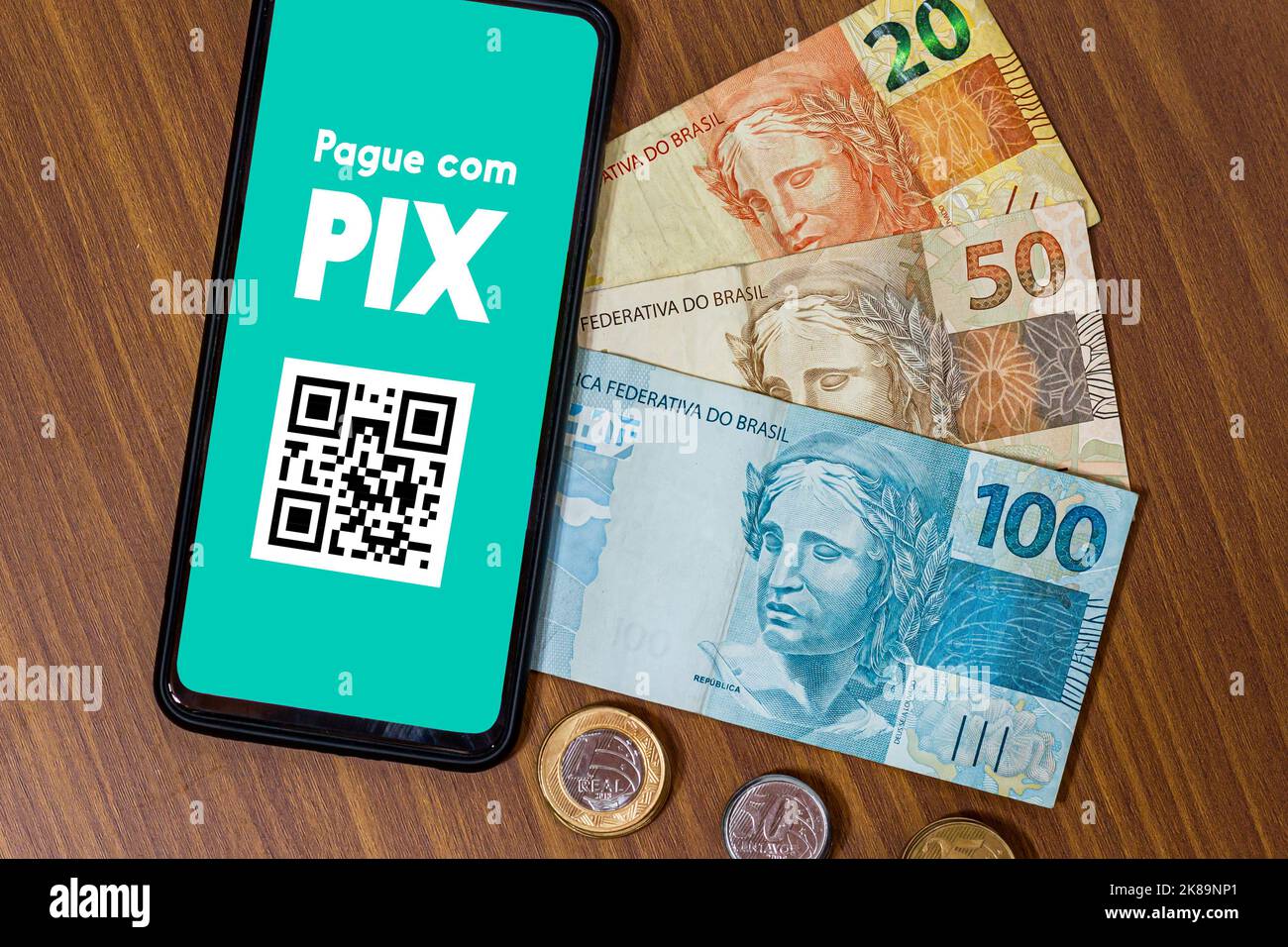 PIX sullo schermo dello smartphone con più monete intorno. PIX è il nuovo sistema di pagamento e trasferimento del governo brasiliano e brasiliano Foto Stock