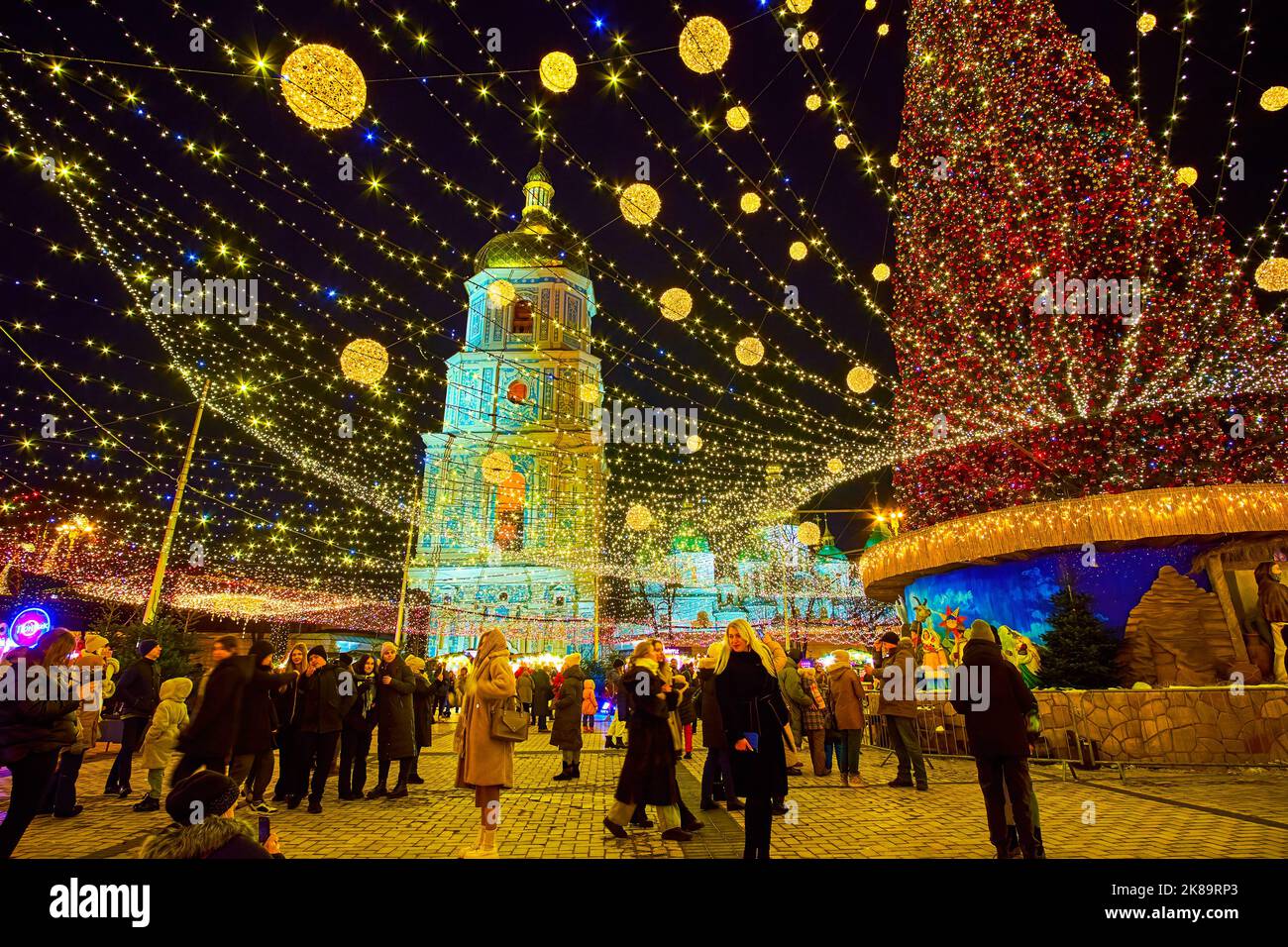 KIEV, UCRAINA - 28 DICEMBRE 2021: L'affollata Piazza Sophia durante la Fiera di Natale con una vista su albero di Natale decorato, il campanile di Santa Sofia Foto Stock