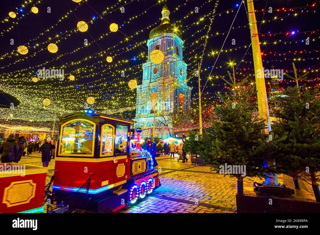 KIEV, UCRAINA - 28 DICEMBRE 2021: Piazza Sophia decorata con affollata Fiera di Natale, albero di Natale principale, a cavallo treno turistico e Santa Sofia Chathi Foto Stock