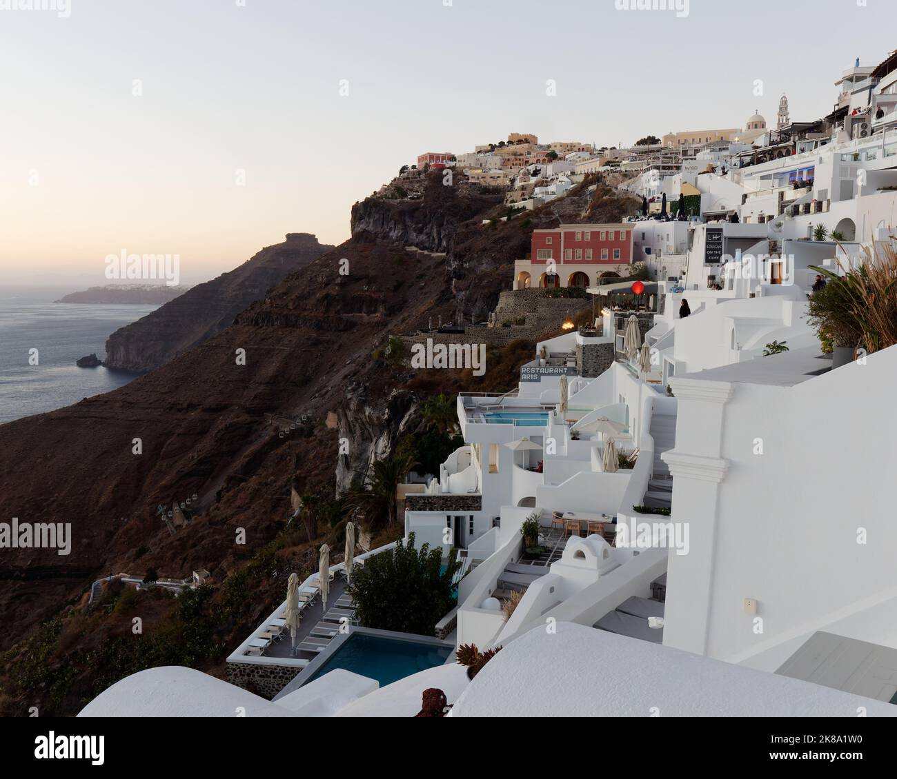 Città di Fira con Skaros Rock lasciato in serata. Isole Cicladi greche di Santorini nel Mar Egeo Foto Stock