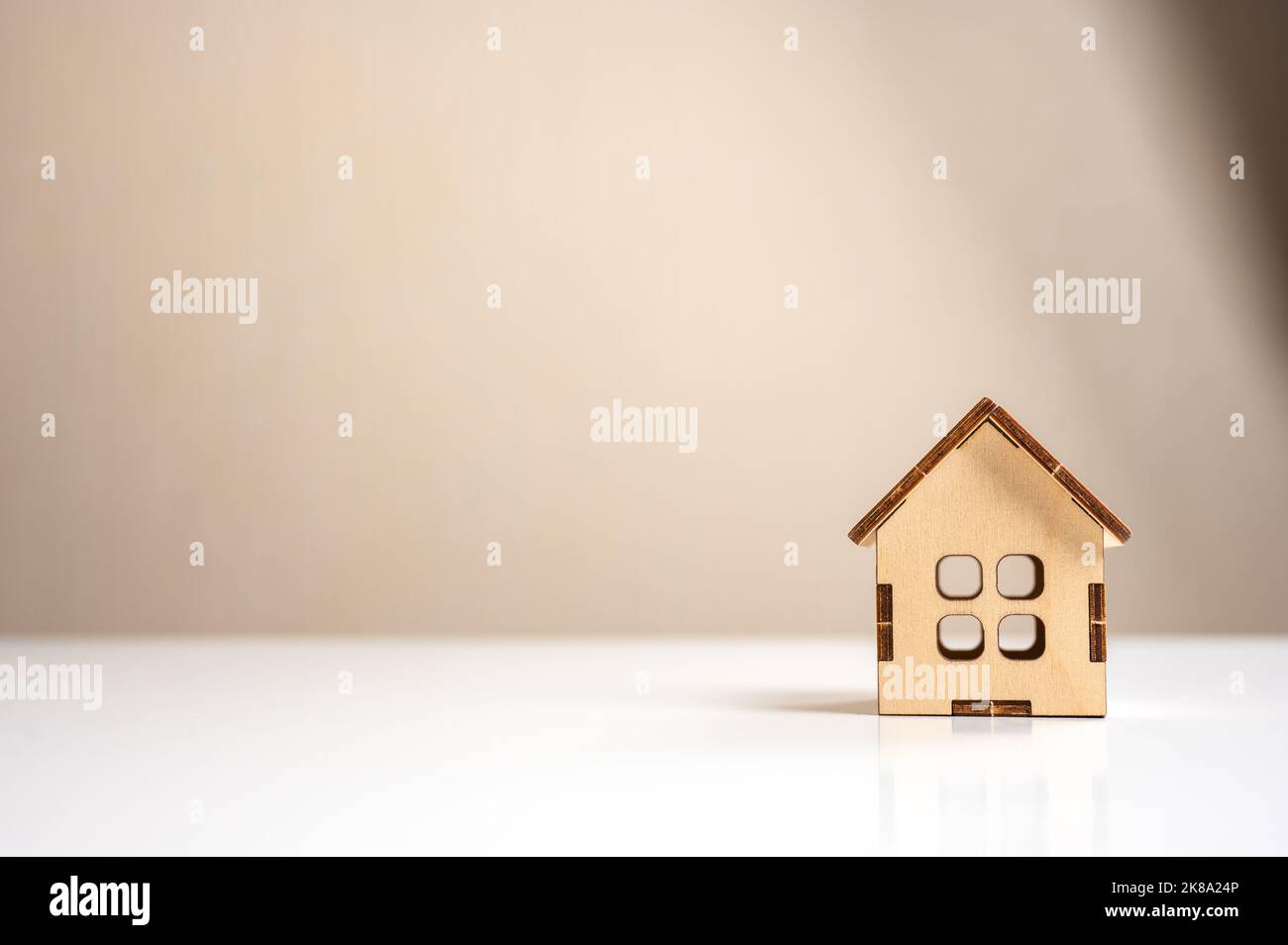 modello di casa in legno su tavolo bianco. Casa artigianale residenziale mini. Costruzione, ipoteca, immobiliare. Acquisto di casa e di concetto di costo di proprietà Foto Stock