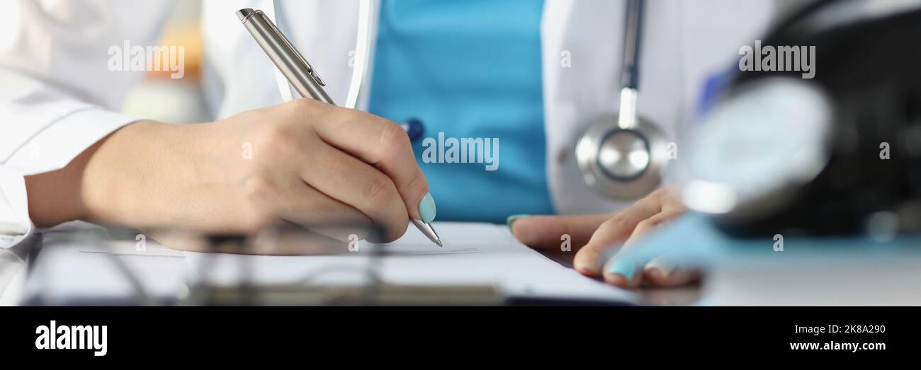 Medico riempire l'anamnesi della malattia del paziente o prescrivere farmaci per il cliente, medico occupato Foto Stock