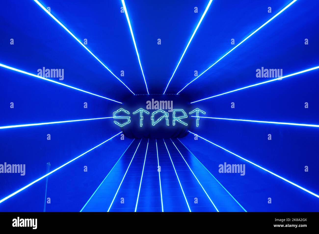 Sfondo blu con raggi laser e testo Start. Sfondo per la schermata iniziale per giochi, cybersport e metaverse. Foto Stock