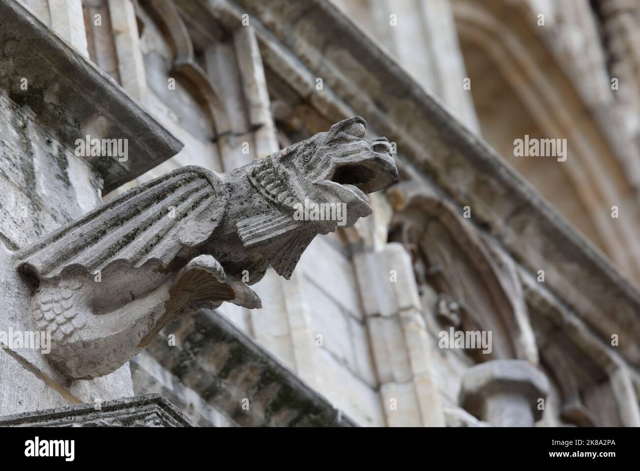 Statua mostruosa con caratteristiche quasi umane chiamato gargoyle sulla facciata dell'edificio storico Foto Stock
