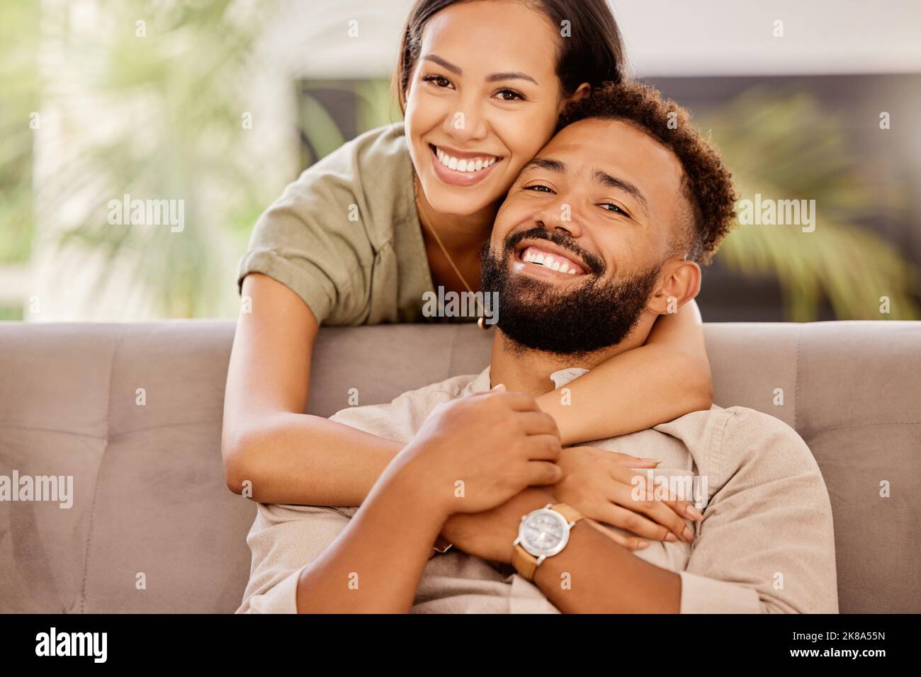 Sorridi, amore e ritratto di coppia sul divano per felice, sostegno e abbraccio insieme con la connessione. Relax, partner e pace con l'uomo e la donna nel vivere Foto Stock