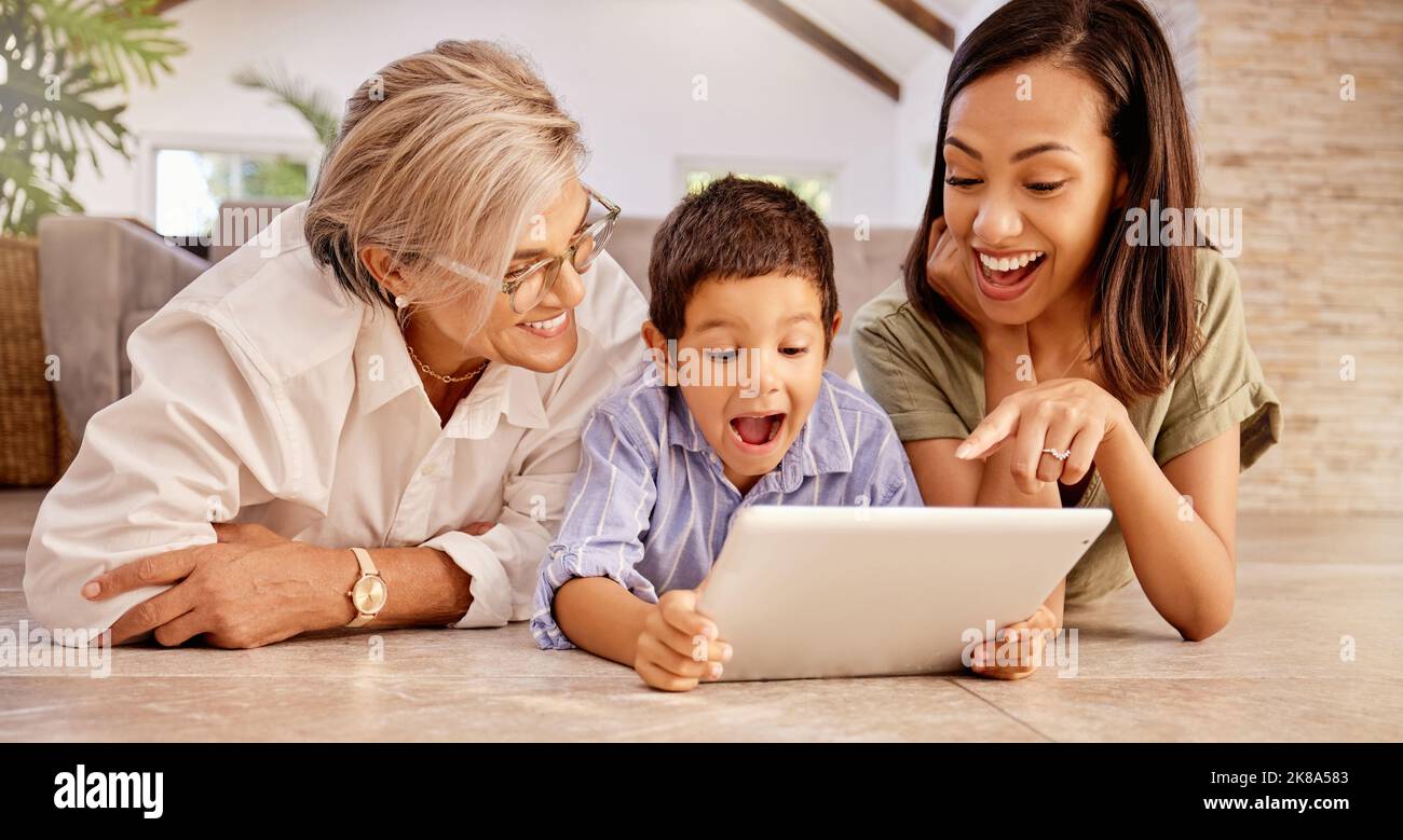 Tablet, e learning e wow di bambino con nonna per l'istruzione online, giochi su Internet o l'insegnamento di siti web. Donna anziana e mamma con sostegno, amore Foto Stock