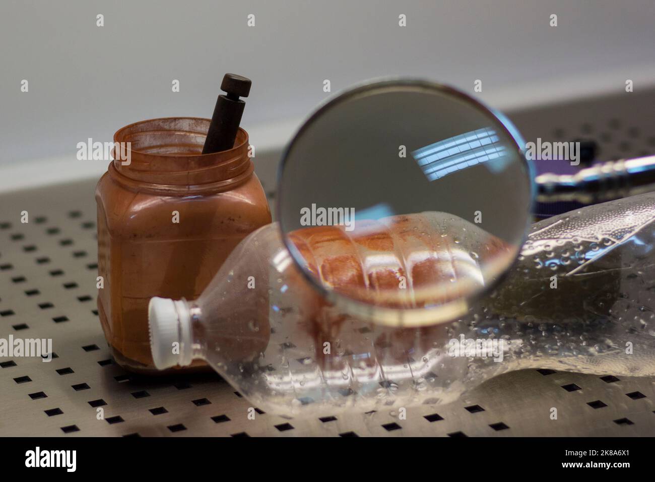 L'esperto forense esamina l'oggetto dell'esame per verificare la presenza di impronte digitali Foto Stock