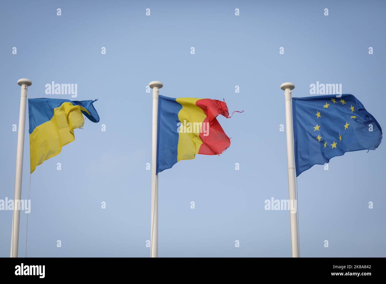 Bandiere ucraine, rumene e dell'Unione europea usurate in un valico di frontiera tra Ucraina e Romania. Foto Stock