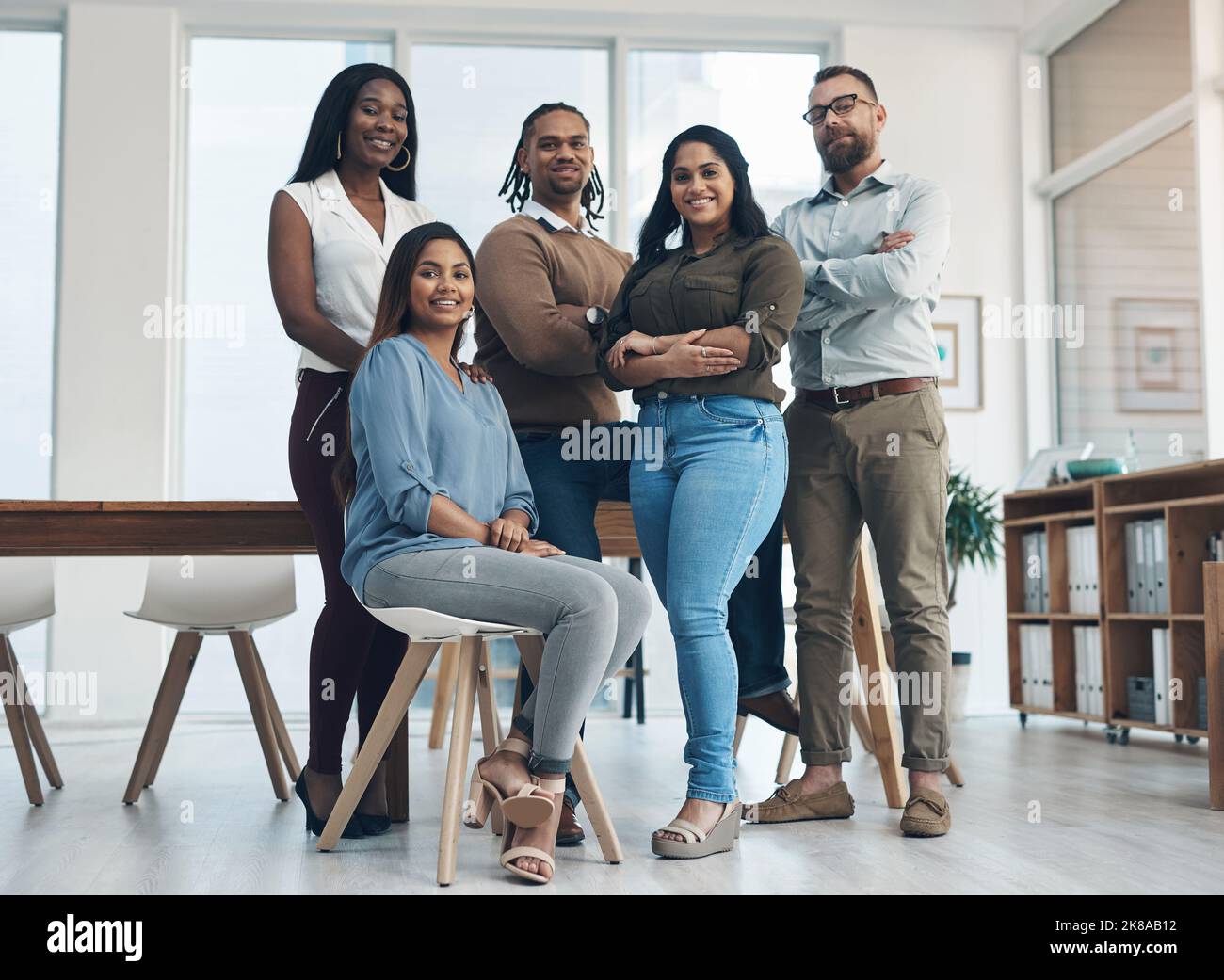 Offriamo più di quanto ci si aspetta da noi. Ritratto completo di un gruppo diversificato di uomini d'affari che si trovano in ufficio durante il giorno. Foto Stock