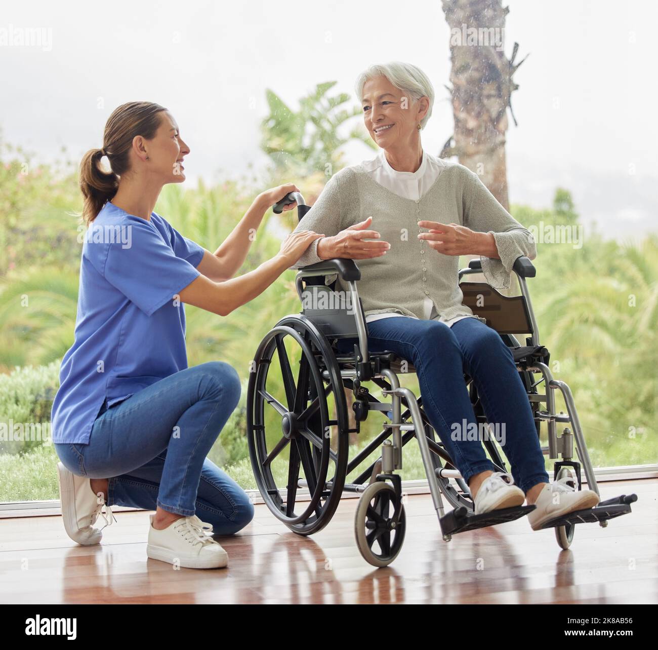 Disabilità, donna anziana in sedia a rotelle e infermiera hanno conversazione, parlare e di assistenza sanitaria. Dottore, donna matura e donna dare Foto Stock